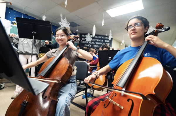 BELIEVE • Junior Kaitlyn Ho and senior Sage Baker play their cellos during “The Polar Express” themed pop-up concert on the second floor during fifth block on Monday, December 10.